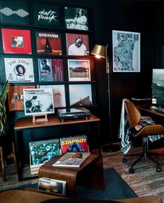 a room with various records on the wall and a desk in front of it,