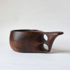 a wooden object with holes in it on a white surface