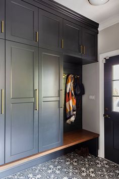 a black and white tiled floor next to gray cabinets