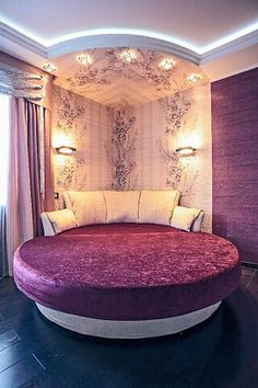 a large round bed sitting in the middle of a room