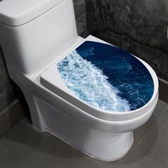 a white toilet with blue water printed on the lid