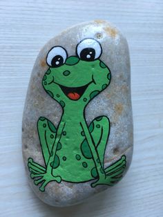 a painted frog sitting on top of a rock