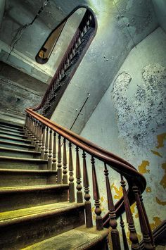 an old stair case with peeling paint on the walls