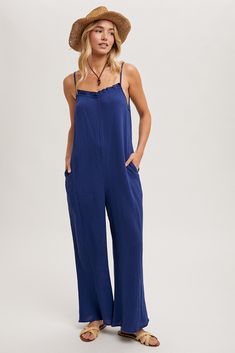 A cotton material jumpsuit with adjustable spaghetti straps. This jumpsuit has a ruffled neckline, wide legs, and side pockets. Style with wedges and a cute brim hat for lunch with your gal pals. Model is 5'10" and wearing her true size Small. Small: Bust 17", Length 57.5" 100% Cotton Jumpsuits And Rompers With Adjustable Straps For Day Out, Adjustable Straps Overall Jumpsuit For Day Out, Summer Vacation Overalls, Trendy Cotton Beach Overalls, Adjustable Straps Jumpsuits And Rompers For Day Out, Trendy Cotton Overalls For The Beach, Summer Overalls For Vacation, Cotton Jumpsuits And Rompers With Tie Straps For Vacation, Cotton Jumpsuit With Tie Straps For Vacation