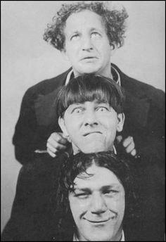 an old black and white photo of three people with one man's head in the air