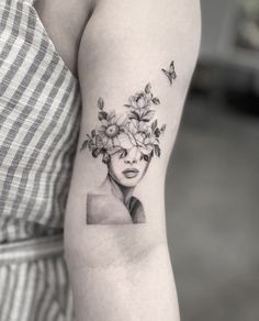 a woman's face with flowers on her head and butterflies flying around the neck