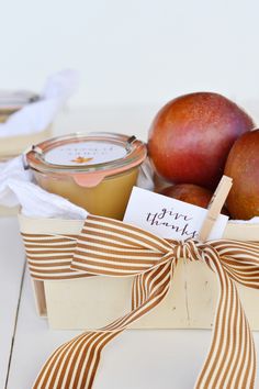 apples, pears and jam in a wooden box with a ribbon tied around it