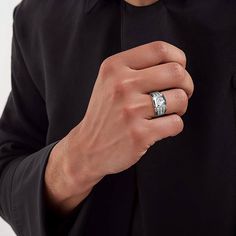 a man wearing a wedding band with a diamond ring on his finger in front of him