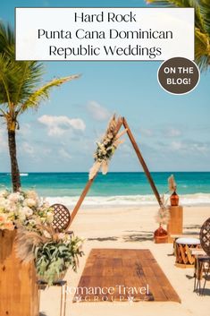 an outdoor ceremony setup on the beach with palm trees and flowers in front of it