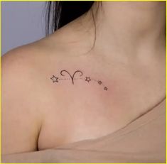 a woman with a small tattoo on her chest that has stars in the shape of a heart