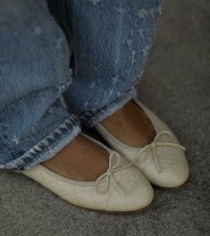 a close up of a person's feet wearing white shoes with laces on them