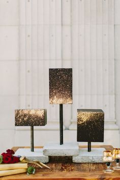 a wooden table topped with speakers next to candles and flowers on top of each other