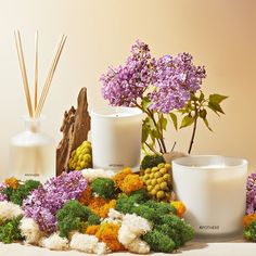 three vases with flowers and candles on a table