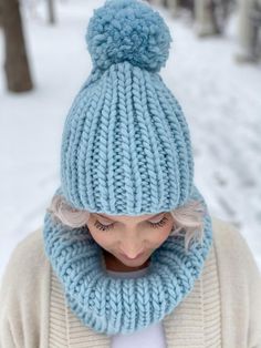 a woman wearing a blue knitted hat and scarf