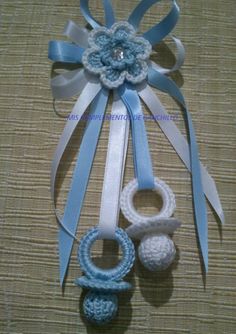 two crocheted items are tied together on a piece of cloth with a bow