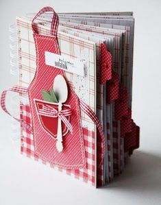 a red and white card with an apron on it's pocket, holding a spoon