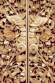 an intricately carved wooden door with birds and flowers