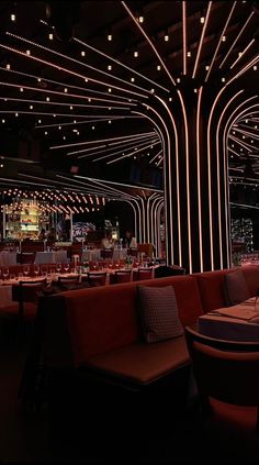 a dimly lit restaurant with red booths and white lights on the ceiling is seen in this image