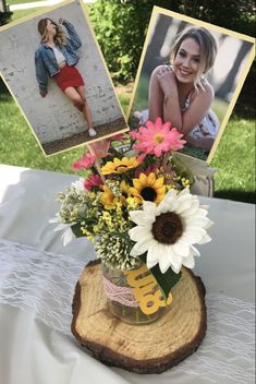 an arrangement of flowers in a vase on a table with two pictures and a card