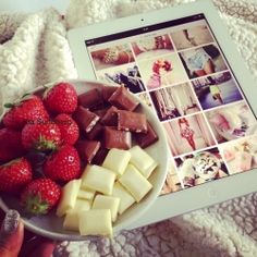 a person holding a tablet with pictures on it and strawberries in front of them