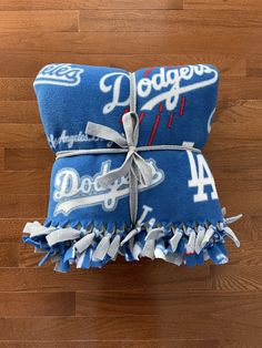 two dodgers towels tied up on top of each other in front of a wooden floor