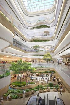 the inside of a shopping mall with people walking and riding on an escalator