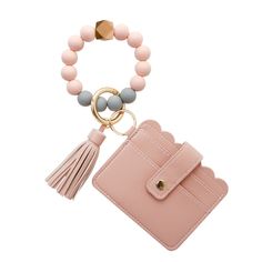 a pink wallet with a tasseled keychain and a beaded ring