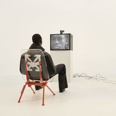 a man sitting in a chair watching tv