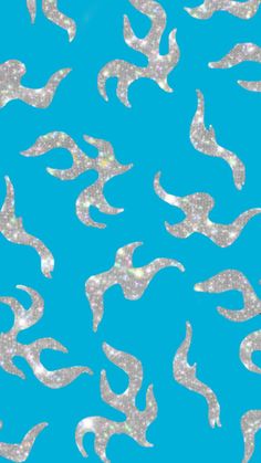 a blue background with silver swirls and sparkle on the bottom right hand corner is an image of birds flying in the sky