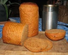 two loaves of bread sitting on top of a cutting board next to a can