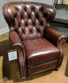 a brown leather chair sitting on top of a carpet