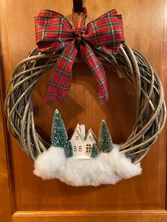 a wreath with a house and trees on it