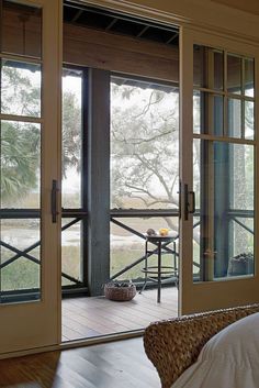 an open door leading to a deck with a table and chairs in the room next to it