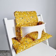 a white chair with yellow flowers on it