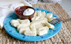 a blue plate topped with cut up bananas next to a small bowl of cream cheese