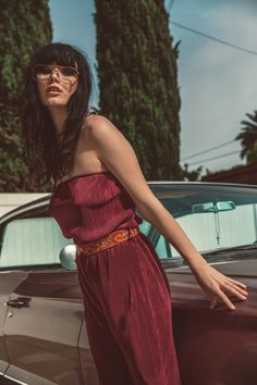 a woman leaning on the hood of a car