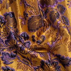 Step into the royal gardens of this Metallic Antique Gold, Purple and Navy Floral Delight Luxury Brocade! Bronze, navy, and purple flowers unfold across a golden ground. Their ornate metallic leaves bubble from the surface to create a three-dimensional face, giving this lustrous fabric an air of complexity and luxury. The semi-structured drape creates voluminous silhouettes for special occasions; imagine stunning ball gowns, sumptuous circle skirts, unique corsets, structured jackets, and more! Luxury Elegant Brocade Embroidered Fabric, Embroidered Brocade Fabric In Gold, Festive Gold Brocade Embroidered Fabric, Festive Gold Brocade Fabric, Gold Drapes, Gold Brocade Fabric With Intricate Embroidery, Mood Designer Fabrics, Royal Garden, Mood Fabrics