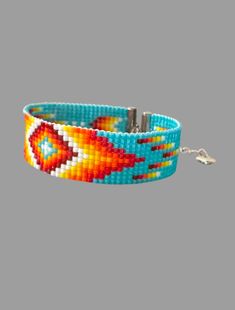 For your consideration is this striking handwoven bracelet with a Native American or geometric flair. The vibrant colorful patterns are crafted using the loom technique and a variety of colorful Miyuki beads, showcasing artistry and contemporary style. Perfect for adding a pop of color and cultural flair to any outfit. The bracelet measures at just about 7 inches and has a 1.5 inch extender finished with the tiny little heart charm. It is soft, supple, and shiny, with the shininess particularly Patterns Colorful, Native American Style, Native American Fashion, Miyuki Beads, Geometric Patterns, Seed Bead, Diy Bracelets, American Style, Heart Charm