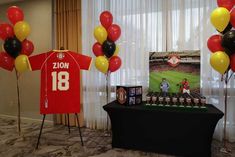 balloons are in the shape of shirts on display at a sports themed birthday party with photos and decorations