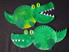 paper plate crocodiles made to look like they are wearing green and yellow shirts with their mouths open