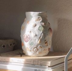 a white vase sitting on top of two books