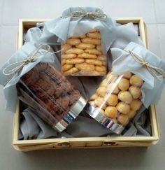 a wooden box filled with pastries wrapped in blue paper and twinkied together