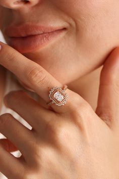 a close up of a person wearing a ring with an oval shaped diamond on it