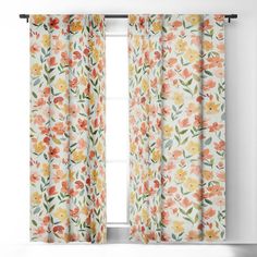 an orange and yellow floral curtain hanging on a window