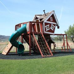 a wooden play set with a green slide