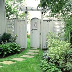 a white gate in the middle of a green yard