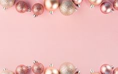 pink and gold christmas ornaments on a pink background with copy - space in the middle