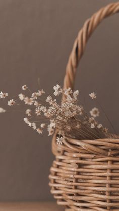 a wicker basket with white flowers in it