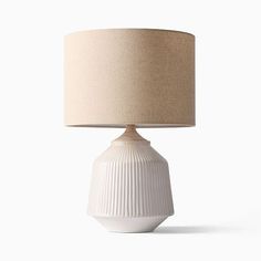 a white table lamp with a beige shade