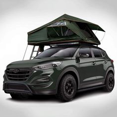 a green suv with a roof tent on it's top and the hood up